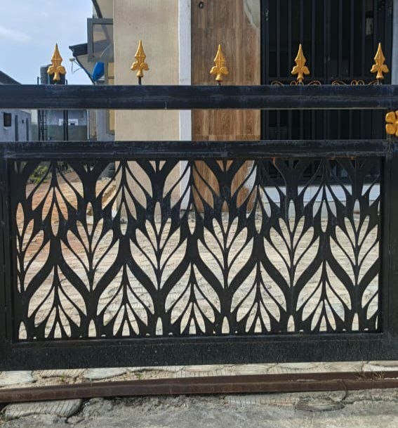 Black laser-cut sliding gate with gold spear tips
